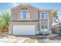 Two-story home featuring a two-car garage, desert landscaping and tile roof at 9143 W Harmony Ln, Peoria, AZ 85382