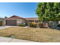 Charming single-story home featuring a tile roof, well-manicured yard, and an attached two-car garage at 1296 Leisure World --, Mesa, AZ 85206