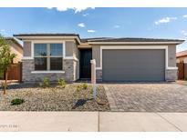 Charming single-story home featuring stone accents, a gray garage door, and a well-manicured front yard at 18507 E Camila Dr, Gold Canyon, AZ 85118