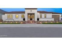 Charming single-story home with a clay tile roof, lighted brick path, and manicured landscaping at 17448 W Carlisle Dr, Surprise, AZ 85388