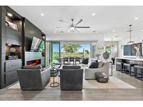 Bright living room with a modern fireplace, sleek built-ins, and a sliding glass door to the patio at 17316 W Wildwood St, Surprise, AZ 85388
