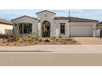 Charming single-story home featuring a white exterior, tile roof, arched entryway, and a meticulously landscaped front yard at 4315 S 123Rd Ave, Avondale, AZ 85323