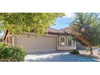 Beige house with a two-car garage and landscaping at 21129 N Grantham Rd, Maricopa, AZ 85138