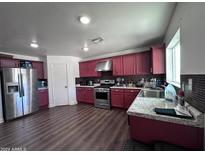 Bright kitchen with stainless steel appliances and dark wood cabinets at 6245 W Southgate St, Phoenix, AZ 85043