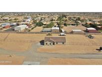 Expansive aerial view of a single-story home on a large lot with outbuildings and desert landscaping at 22352 W Gamble Ln, Wittmann, AZ 85361