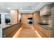 Modern kitchen featuring wood cabinets, stainless steel appliances, and stone countertops at 7127 E Rancho Vista Dr # 4001, Scottsdale, AZ 85251