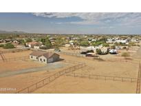 Expansive aerial view showcases the desert home with a fenced yard and community views at 22378 W Gamble Ln, Wittmann, AZ 85361