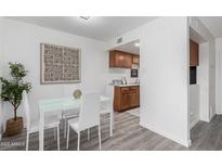 Bright dining area featuring a modern white table and chairs, complemented by stylish decor and wood-look floors at 4032 W Reade Ave, Phoenix, AZ 85019