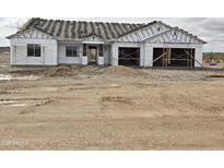 New construction home featuring a two-car garage and partially installed roof in a desert landscape at 1973 W Brooke Ln, Queen Creek, AZ 85144