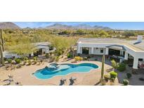 Stunning aerial view of a backyard pool with a spa and lounge chairs on a paved patio at 25583 N 89Th St, Scottsdale, AZ 85255