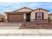 Attractive single-story home with a brown garage door and landscaped front yard at 19637 W Cartwright Ave, Buckeye, AZ 85396