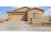 Tan single-story home featuring a two-car garage and neutral desert landscaping at 680 W Crowned Dove Trl, Casa Grande, AZ 85122