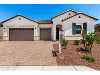 Charming single-story home featuring a brick driveway, three-car garage, and well-maintained landscaping at 20262 W Hollyhock St, Buckeye, AZ 85396