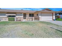 Charming single-story home features a front yard with a walkway and attached garage at 10802 W Cameo Dr, Sun City, AZ 85351