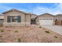 Charming single-story home features desert landscaping, stone accents, and a two-car garage at 10434 S 48Th Gln, Laveen, AZ 85339