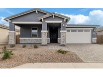 One-story home with gray siding, stone accents, and a two-car garage at 40519 W Wade Dr, Maricopa, AZ 85138