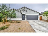 Charming single-story home featuring a two-car garage, desert landscaping, and modern architectural details at 1157 W Paradise Way, Casa Grande, AZ 85122