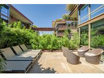 Private patio with dining table, lounge chairs, and lush landscaping, perfect for outdoor entertaining at 7127 E Rancho Vista Dr # 4012, Scottsdale, AZ 85251
