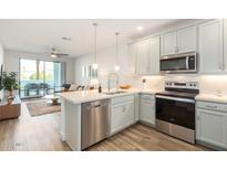 Bright kitchen features stainless steel appliances, pendant lighting, and a convenient breakfast bar at 2511 W Queen Creek Rd # 179, Chandler, AZ 85248