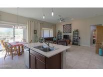 Open-concept kitchen flowing into the living room with a large island, natural light, and neutral color scheme at 5074 N Scottsdale Rd, Eloy, AZ 85131