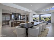 Open dining area features a modern table with plush chairs and a large island with seating at 37200 N Cave Creek Rd # 2110, Scottsdale, AZ 85262