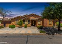 Charming single-story home with desert landscaping, neutral stucco and brick, and a welcoming front porch at 13421 N 151St Dr, Surprise, AZ 85379