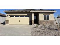 One-story house with beige exterior, stone accents, and a two-car garage at 610 W Pintail Dr, Casa Grande, AZ 85122