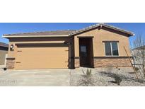 Tan house with a two-car garage and desert landscaping at 626 W Pintail Dr, Casa Grande, AZ 85122