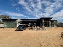 Contemporary home's exterior featuring black accents, a truck in the driveway, and construction materials at 12232 N 65Th Pl, Scottsdale, AZ 85254