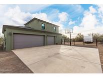 Exterior view of attached two-car garage with basketball hoop and expansive driveway, with ample space for vehicles at 38334 N 20Th St, Phoenix, AZ 85086