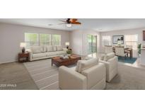 Spacious living room with light beige furniture, wood coffee table, and access to backyard at 17214 W Gibson Ln, Goodyear, AZ 85338
