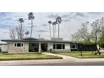 Charming single-story home with stone accents, a covered porch, and lush lawn at 895 W Tyson St, Chandler, AZ 85225