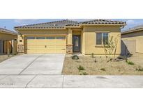 Charming single-story home featuring a two-car garage, desert landscaping, and a tile roof at 24606 W St Catherine Ave, Buckeye, AZ 85326
