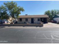 Modest single-story home with a mature tree in the front yard and a covered carport at 5559 N 62Nd Ave, Glendale, AZ 85301