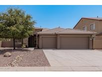 Tan three-car garage house with stone accents and a landscaped front yard at 3407 E Glacier Pl, Chandler, AZ 85249