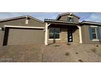 Charming single-Gathering home with a two-car garage and beautiful brick and stone accents at 16994 W Canterbury Dr, Surprise, AZ 85388