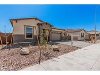 Charming single-story home featuring a neutral color scheme, manicured landscaping, and a welcoming two-car garage at 12007 W Parkway Ln, Avondale, AZ 85323