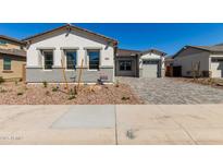 Charming single-Gathering home featuring a brick accent, landscaped front yard, and a paved driveway leading to the garage at 12012 W Parkway Ln, Avondale, AZ 85323