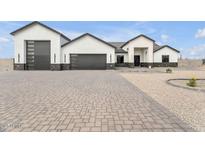Stunning modern home with a large garage and a beautifully paved driveway and desert landscape at 32278 N 168Th Ave, Surprise, AZ 85387