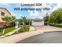 Beautiful single-story home with a landscaped front yard and three-car garage at 10803 E Ramblewood Cir, Mesa, AZ 85212