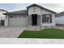 Single-story home with gray exterior, stone accents, and a landscaped front yard at 9987 W Verde Ln, Avondale, AZ 85392