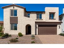 Charming two-story home featuring a brick driveway and a beautifully landscaped front yard at 18002 W Vogel Ave, Goodyear, AZ 85338