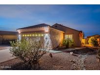 Evening view of a single-story home with a two-car garage and desert landscaping at 10364 E Second Water Trl, Gold Canyon, AZ 85118