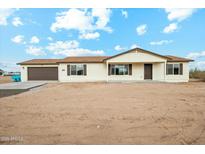 Charming single-story home featuring a brown door, coordinated shutters and a two-car garage at 13628 S 192Nd Ave, Buckeye, AZ 85326