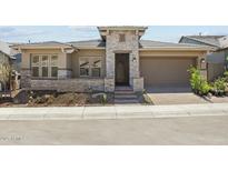 Charming single-story home with stone accents, a well-manicured landscape, and a neutral color palette, inviting curb appeal at 32535 N 135Th Dr, Peoria, AZ 85383
