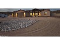 Inviting single-story home with a circular driveway and desert landscaping, presenting a serene curb appeal at 48515 N 13Th Ave, New River, AZ 85087