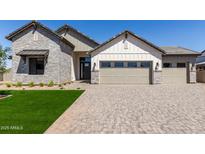 Beautiful exterior elevation of a home showcasing a stone facade, multi-car garage, and manicured lawn at 1606 E Minton St, Mesa, AZ 85203