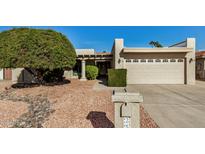 Front view of a single-story home with a two-car garage and well-manicured landscaping at 25809 S Hollygreen Dr, Sun Lakes, AZ 85248