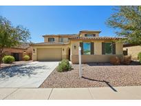 Charming two-story home featuring a three-car garage, desert landscaping, and a tile roof at 19591 W Lincoln St, Buckeye, AZ 85326