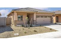 Charming single-story home featuring a neutral color scheme, a two-car garage, and desert landscaping at 6468 S 246Th Ln, Buckeye, AZ 85326